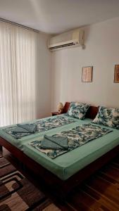 a bedroom with a bed in a room with a window at Sunny houm in Nesebar