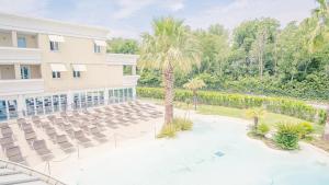 an aerial view of a building with chairs and a palm tree at Residence Relais du Lac Village & Elite in Desenzano del Garda