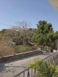 a street with a fence and trees on a hill at Jodhpur House Mount Abu in Mount Ābu