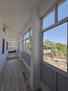 an empty room with a large window with a view at Jodhpur House Mount Abu in Mount Ābu