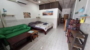 a room with a bed and a green couch at Runa Group House Samed in Ko Samed