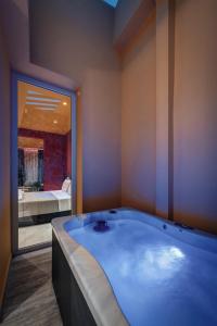 a large blue bath tub in a room with a mirror at ATELIER5 Suites in Ermoupoli +80 photos