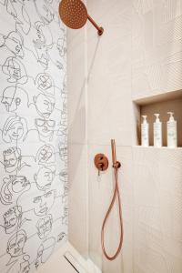 a bathroom with a shower with a face shower curtain at ATELIER5 Suites in Ermoupoli