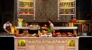two people standing behind a counter with food on it at Mandarin Oriental, Kuala Lumpur in Kuala Lumpur