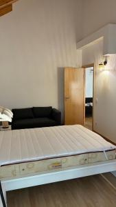 a large bed in a room with a couch at casa 20 centro in Lagos