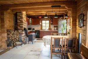 a kitchen with a table and a brick fireplace at Lake House Villa pas Eugenija in Migiškiai