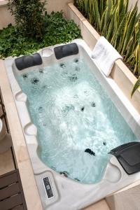 a jacuzzi bathtub in a garden at Magno Collection Palacio de Becas in Seville