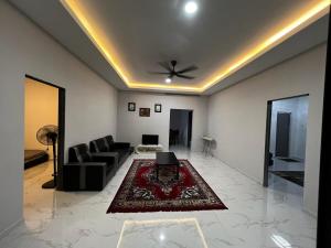 a living room with a couch and a table at DBreeze Homestay in Pengerang