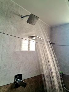 a shower with a shower curtain in a bathroom at ARUL Residency in Mettuppālaiyam +31 photos