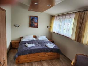 a bedroom with a bed with two towels on it at Ośrodek Wypoczynkowy Niagara in Międzybrodzie Żywieckie +21 photos