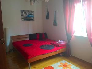 a bedroom with a red bed with a red blanket at Apartment Svetlana in Selce +32 photos