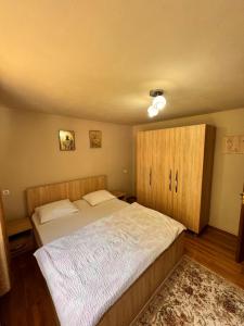 a bedroom with a large bed and wooden cabinets at Pensiunea Emanuel in Gârda de Sus