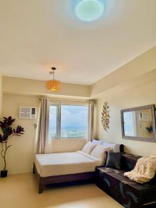 a living room with a couch and a window at Avida Aspira Studio, 27th Floor, Pool & Gym in Cagayan de Oro