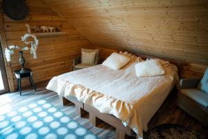 a bedroom with a bed in a wooden room at Lake House Villa pas Eugenija in Migiškiai