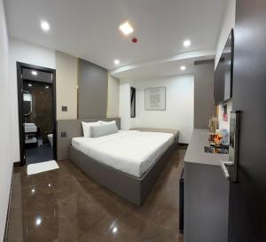 a bedroom with a large white bed and a desk at Kim's Hotel in Buon Ma Thuot