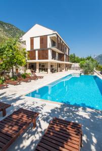 een villa met een zwembad en een huis bij Apartments Feral in Kotor