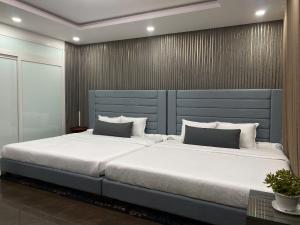a large bed with a blue headboard in a bedroom at Kim's Hotel in Buon Ma Thuot