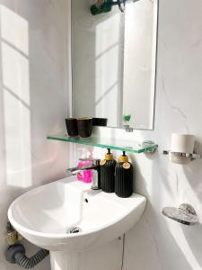 a white bathroom with a sink and a mirror at Lapausa Homestay in Kỳ Vĩ