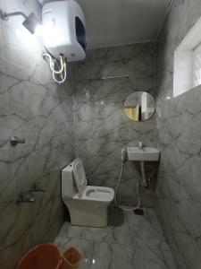 a bathroom with a toilet and a sink at Ronazio Beach View Residency in Auroville