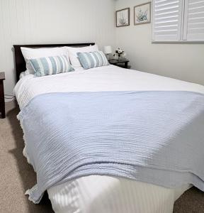 a bedroom with a large white bed with blue pillows at Rainbow House in Rainbow Beach
