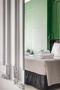 a reflection of a bedroom with a bed in a mirror at ATELIER5 Suites in Ermoupoli
