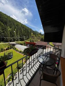 a balcony with a table and chairs and a view at Pensiunea Emanuel in Gârda de Sus