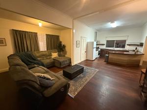 a living room with a couch and a table at Huge comfy 4br home near CBD in Geraldton