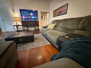a living room with a couch and a flat screen tv at Huge comfy 4br home near CBD in Geraldton +21 photos
