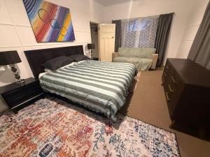 a bedroom with a bed and a living room at Huge comfy 4br home near CBD in Geraldton