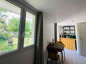 a dining room with a table and a window at Le Cerisier in Giverny