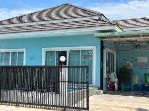 a blue house with a porch and a chair at Baanpeanutsvilla Huahin in Hua Hin