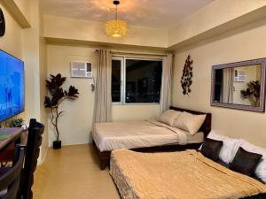 a small bedroom with a bed and a window at Avida Aspira Studio, 27th Floor, Pool & Gym in Cagayan de Oro