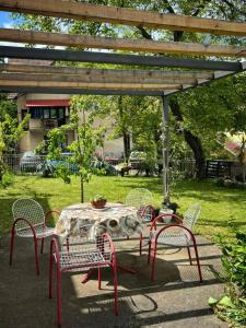 a table and chairs under a pergola in a yard at Apartmani Lucky in Vrnjačka Banja