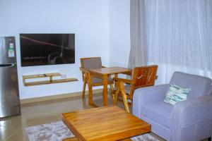 a living room with a couch and a table and a chair at Chama Haven Appartments in Tengeru
