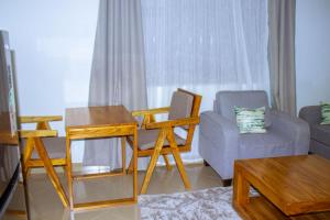 a living room with a couch a chair and a table at Chama Haven Appartments in Tengeru