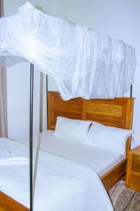 two beds with white sheets on top of each other at Chama Haven Appartments in Tengeru