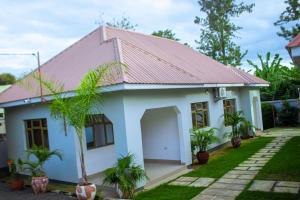 a small white house with a red roof at Chama Haven Appartments in Tengeru