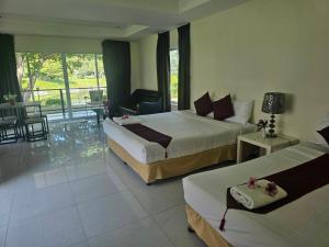 a hotel room with two beds and a balcony at Kaengkrachan Diamond Green Resort in Ban Song Phi Nong +35 photos