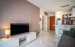 a living room with a flat screen tv on a wall at Monamie-Windsor Park in Adeje +12 photos