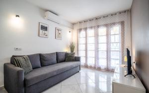 a living room with a couch and a large window at Monamie-Windsor Park in Adeje