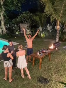 a group of people standing around a table with their hands in the air at Nala's Home in Uluwatu +42 photos