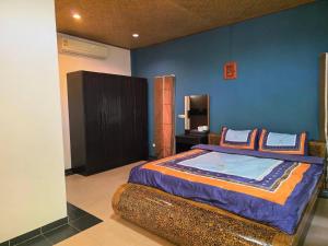 a bedroom with a bed with a blue wall at Tiki Pool Pattaya in Ban Nong Pla Lai