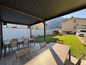 a patio with a table and chairs and a view of a yard at Apartment Jasmina in Venzone