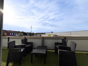 a patio with chairs and a table on a balcony at Appartement Lily-rose in Cerizay
