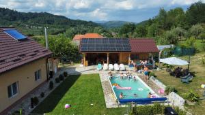 a group of people in a swimming pool next to a house at David House Piscina incalzita si jacuzzi in Pietrari
