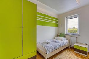ein Schlafzimmer mit grünen Wänden und einem Bett mit Fenster in der Unterkunft Debeli Rtič Apartments in Ankaran