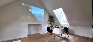 a dining room with a table and chairs and a window at Le Charmant in Dieppe