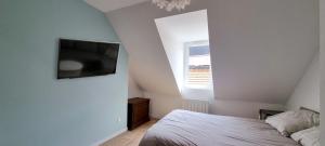 a bedroom with a bed and a flat screen tv at Le Charmant in Dieppe
