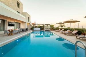 a swimming pool with chairs and a table and umbrellas at Arfna Grand Villa in Afantou