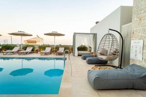 a swimming pool with chairs and a swing next to a pool at Arfna Grand Villa in Afantou